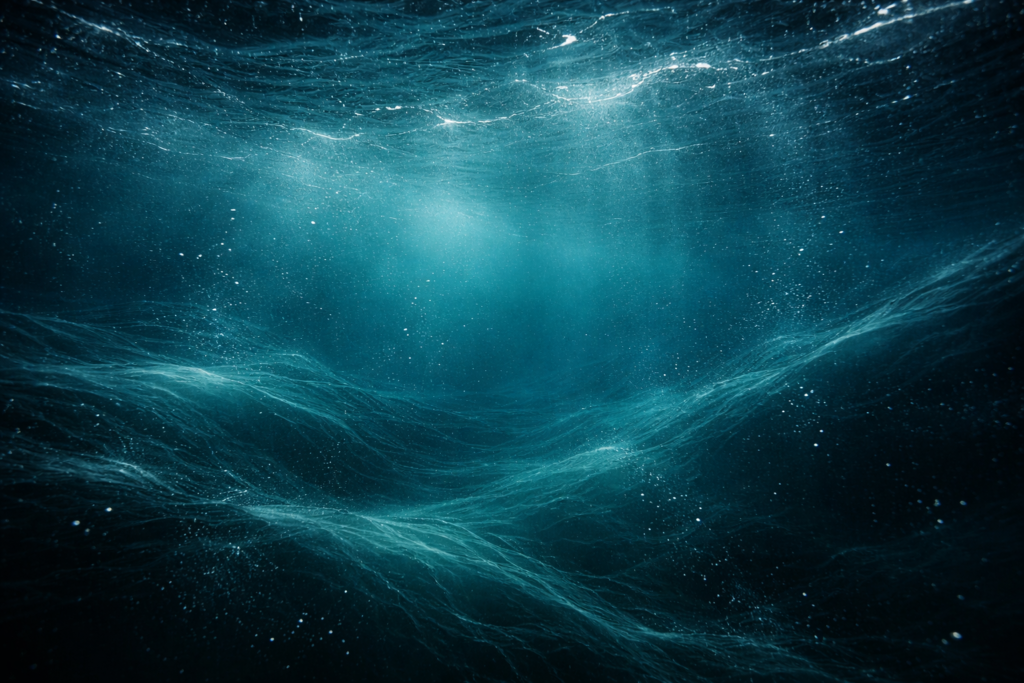 Imagem subaquática mostrando correntes de água em movimento, partículas suspensas e sensação de atividade constante no oceano profundo.