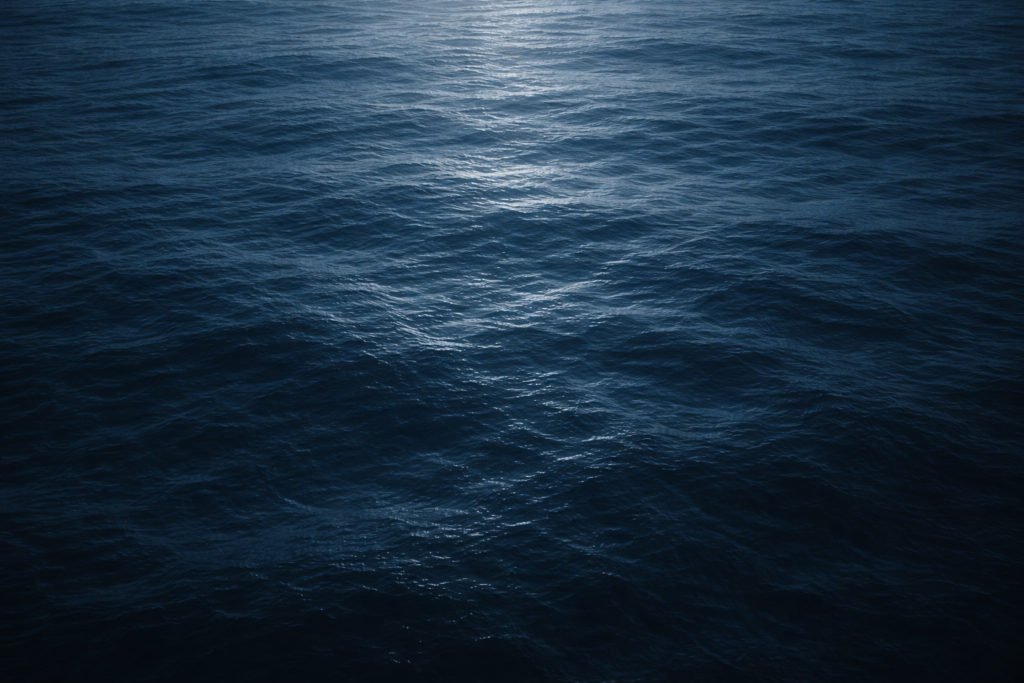 Cena do oceano vista de cima, com superfície azul profunda e aparência calma, sugerindo mistério e sons invisíveis sob a água.